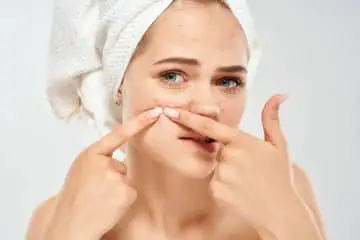 Girl picking pimples on her face