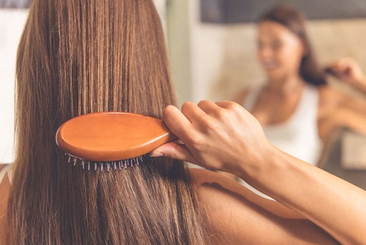 Girl using a hairbrush to brush her hair