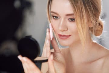 Girl applying powder makeup